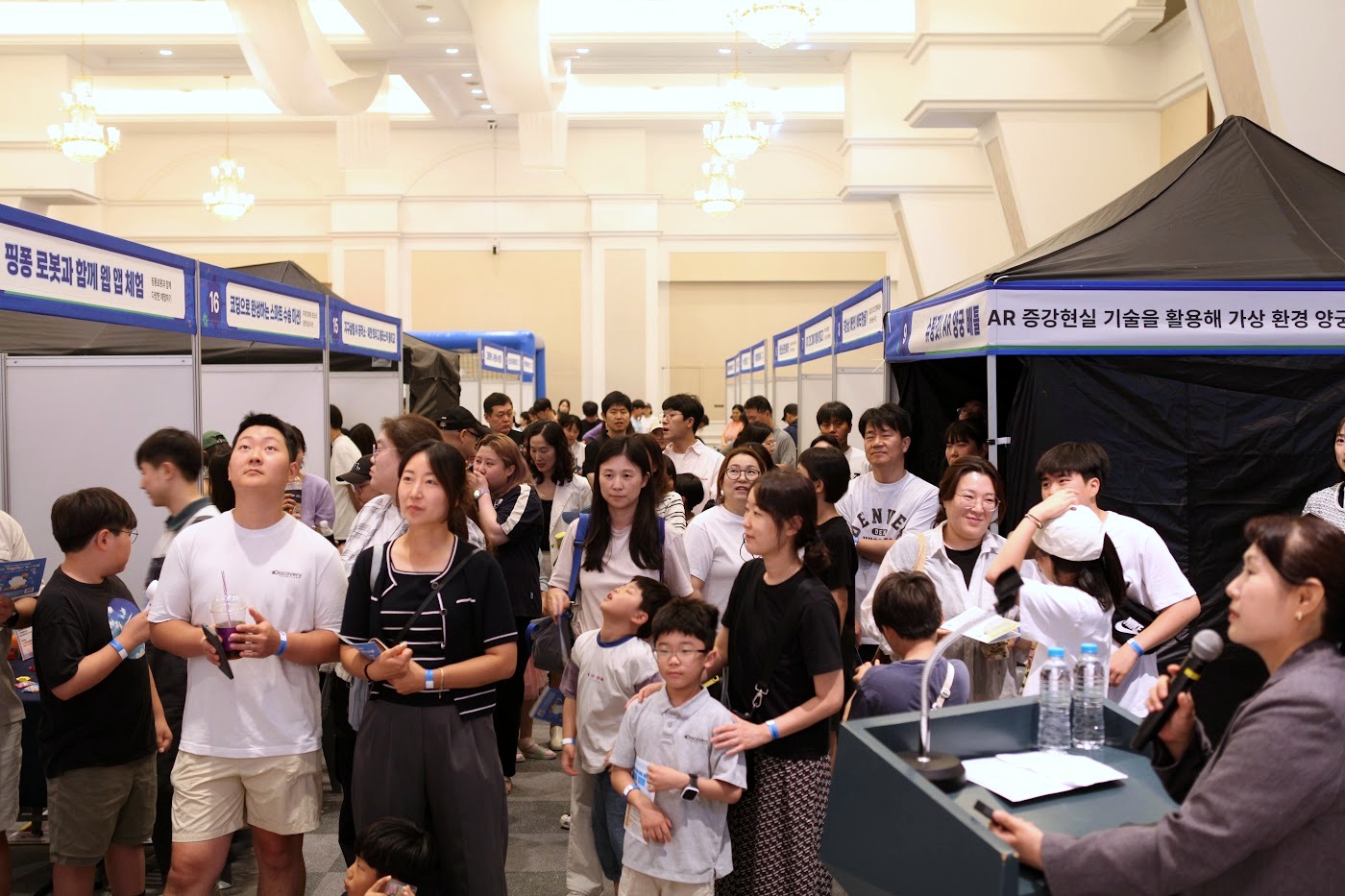 체험부스 앞에서 안내를 받는 학생과 보호자